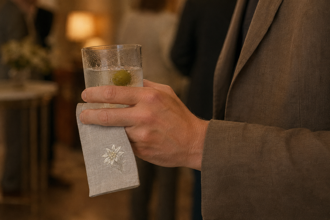 held in one hand with a linen cocktail napkin between the palm and the glass MI RE LA