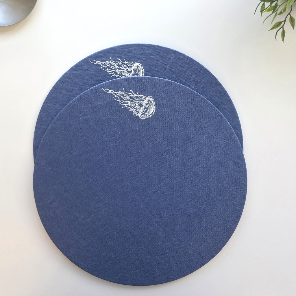 Blue resin-coated linen round placemat wLAith off-white jellyfish embroidery by MI RE 