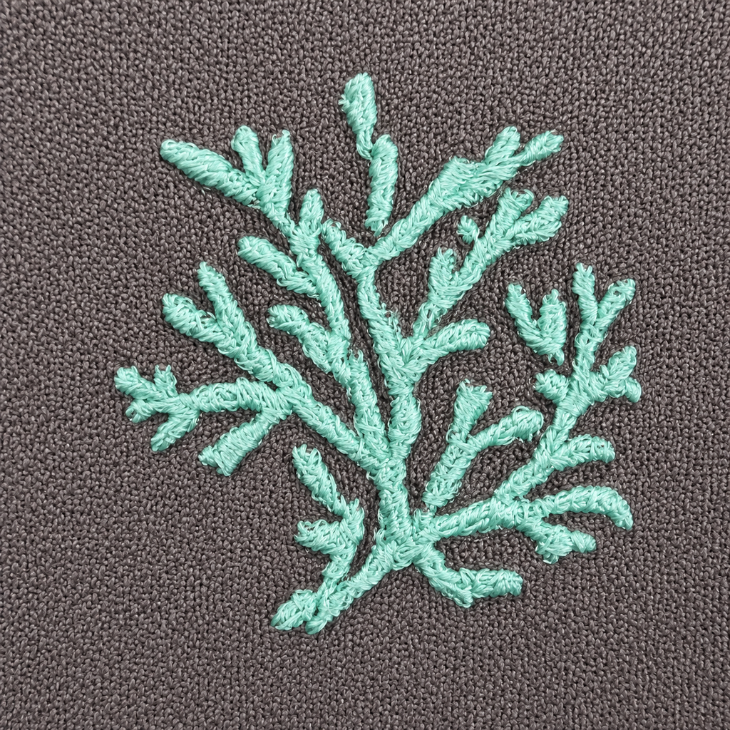 Teal embroidered leaf design on a brown fabric background