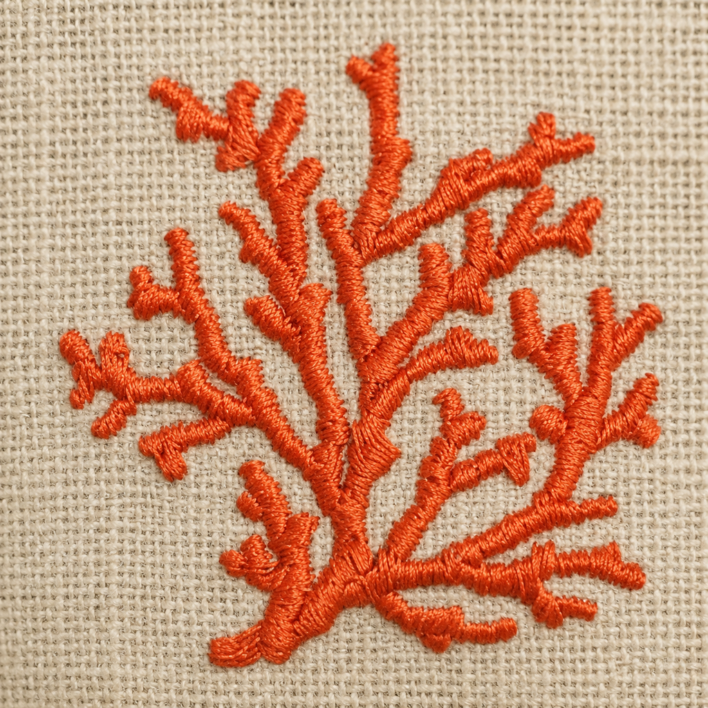Embroidered orange coral design on beige fabric