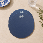 Blue resin-coated linen round placemat with off-white crab embroidery by MI RE LA