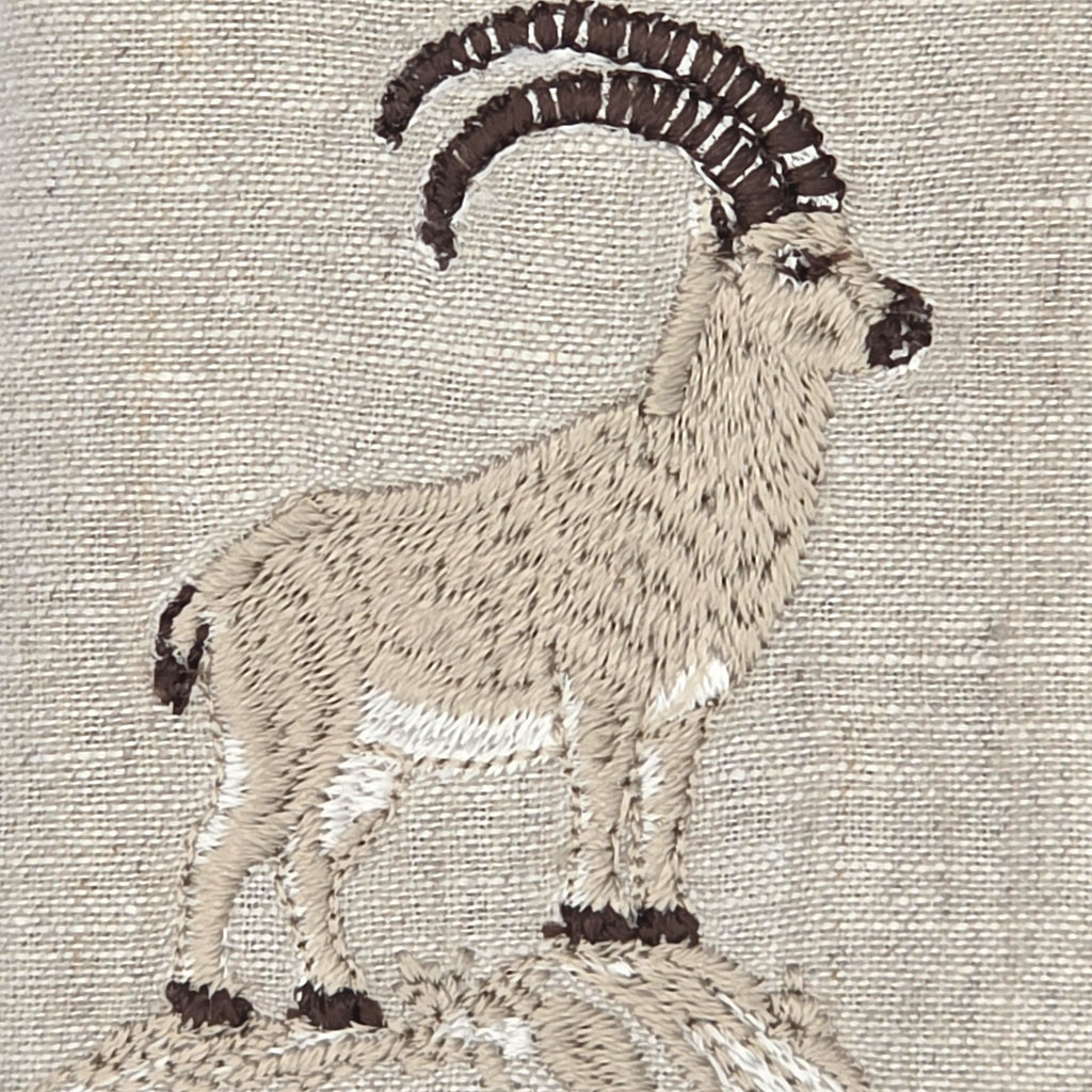 Embroidered mountain Stambecco Ibex design on a beige linen fabric background.