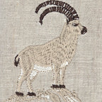 Embroidered mountain Stambecco Ibex design on a beige linen fabric background.