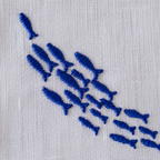 Embroidered pattern of blue fish on a white fabric background