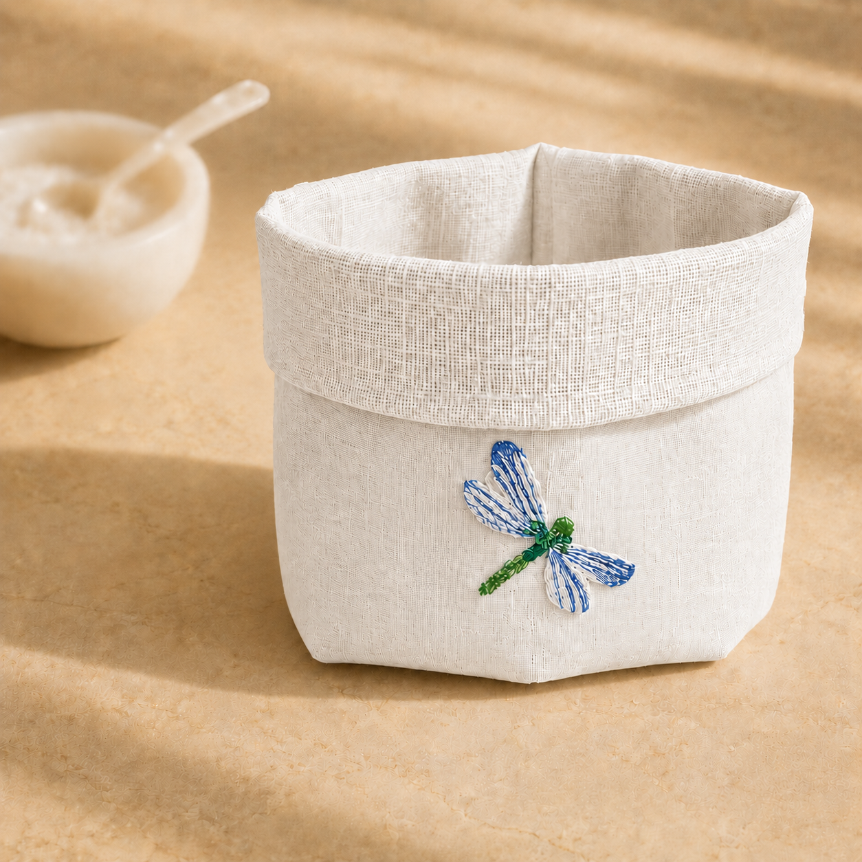 Off-white resin-coated linen basket with dragonfly blue embroidery by MI RE LA