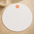 Off-white resin-coated linen round placemat with orange coral embroidery by MI RE LA