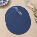 Blue resin-coated linen round placemat with off-white sardine embroidery by MI RE LA
