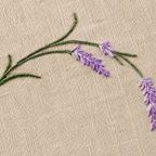 Embroidered lavender flowers on beige fabric